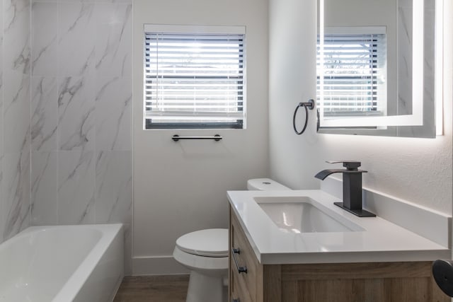 full bathroom with vanity, toilet, tiled shower / bath combo, and hardwood / wood-style floors