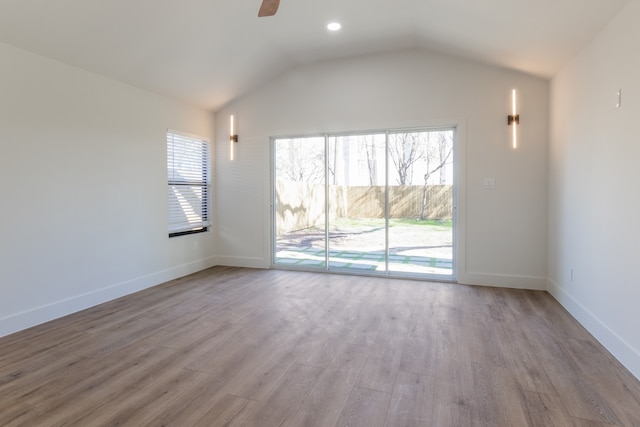 unfurnished living room with ceiling fan, lofted ceiling, and light wood-type flooring