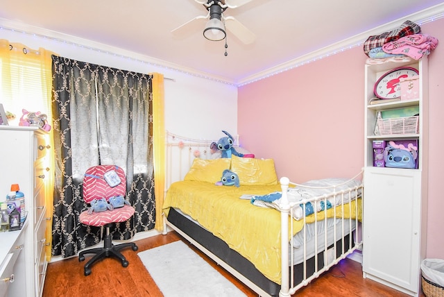 bedroom with ceiling fan, ornamental molding, and wood finished floors