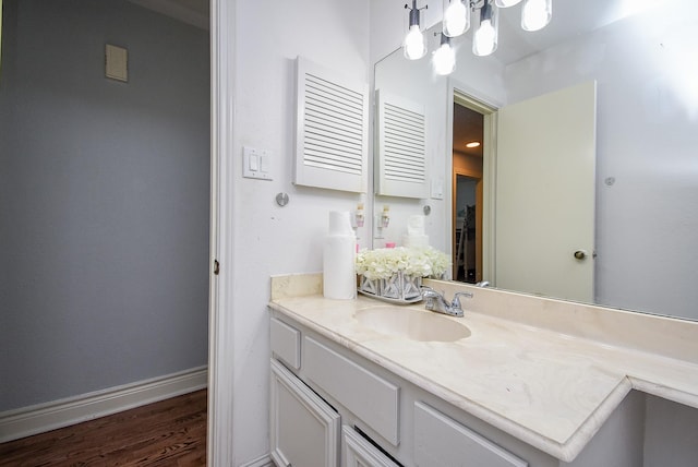 bathroom with baseboards, wood finished floors, and vanity