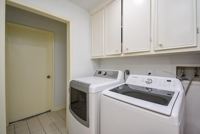 laundry area with washer and dryer, cabinet space, and light tile patterned flooring