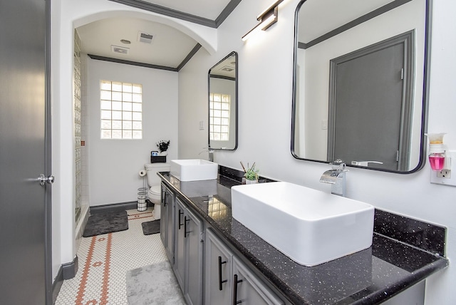 bathroom featuring double vanity, a sink, visible vents, and crown molding