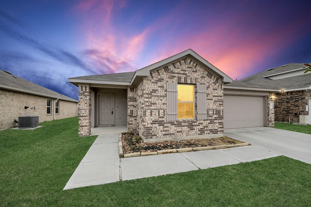 view of front of house featuring cooling unit, a yard, and a garage