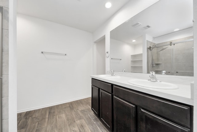 bathroom featuring hardwood / wood-style flooring, vanity, and an enclosed shower