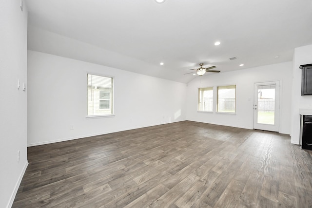 unfurnished living room with lofted ceiling, dark hardwood / wood-style floors, and ceiling fan