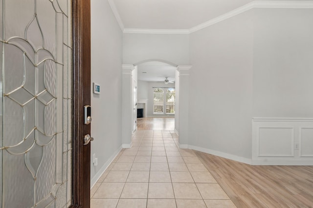 entryway with light hardwood / wood-style flooring, ceiling fan, decorative columns, and ornamental molding