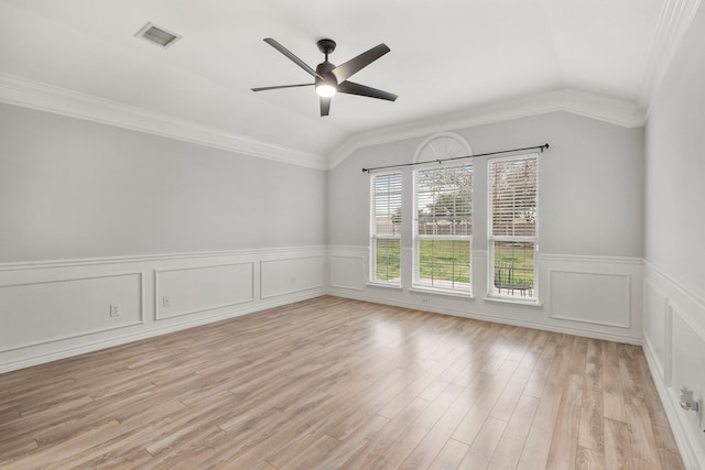 spare room featuring light hardwood / wood-style floors, vaulted ceiling, ceiling fan, and crown molding