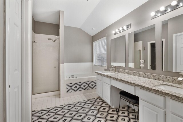 bathroom featuring tile patterned floors, separate shower and tub, vanity, and lofted ceiling