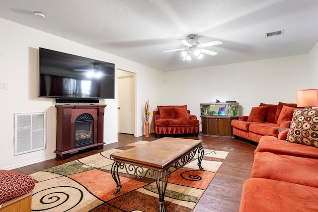 living room with ceiling fan and dark hardwood / wood-style flooring