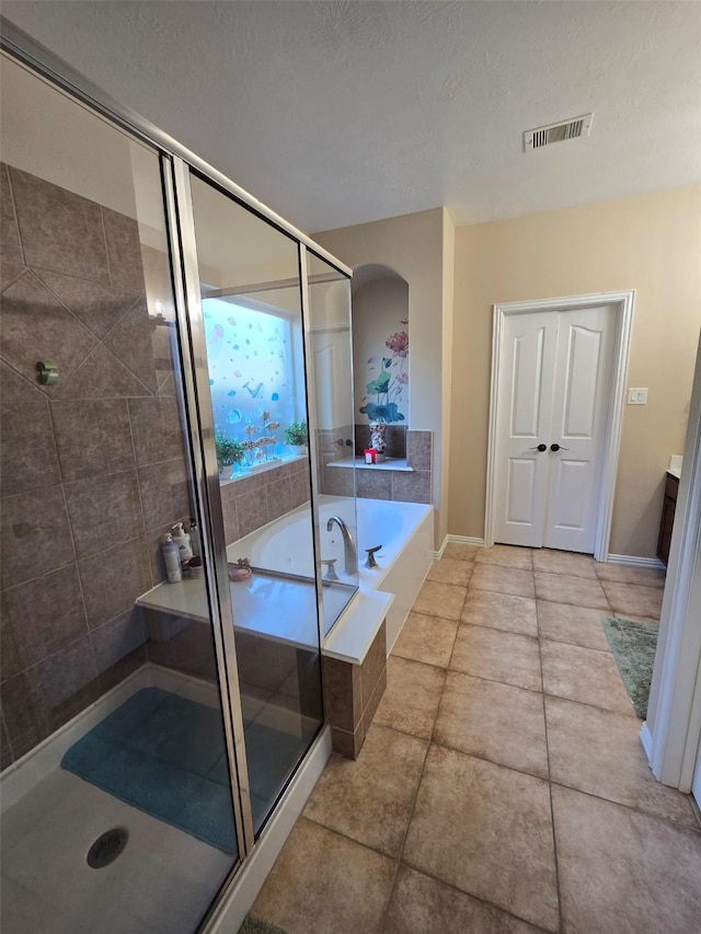 bathroom with tile patterned flooring, a textured ceiling, vanity, and independent shower and bath