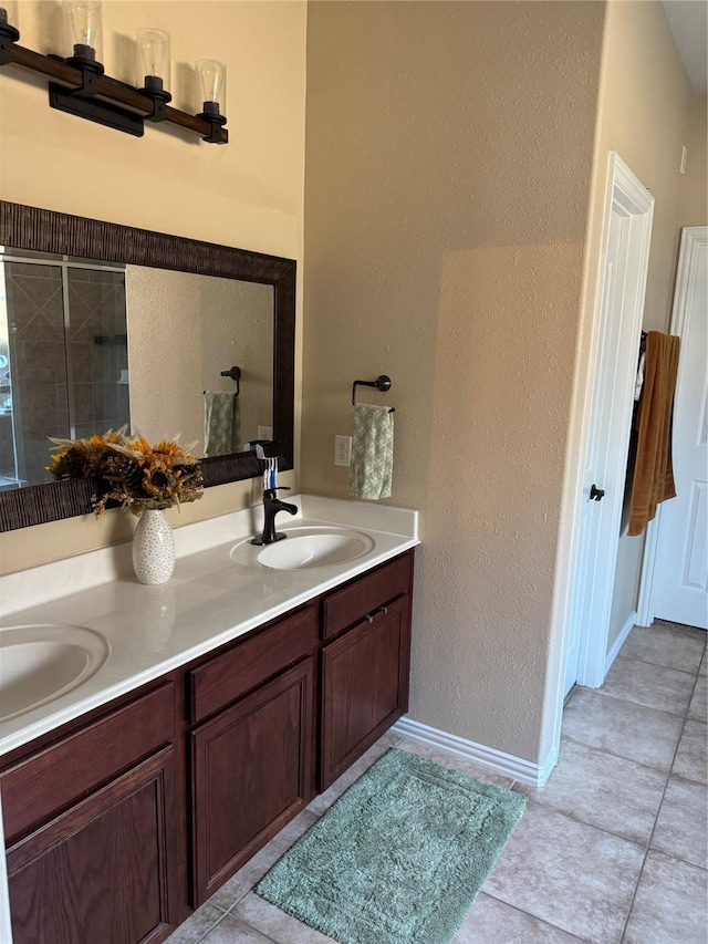 bathroom featuring tile patterned flooring, vanity, and walk in shower