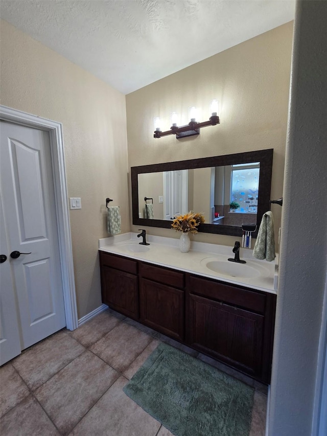 bathroom with tile patterned flooring, a textured ceiling, and vanity