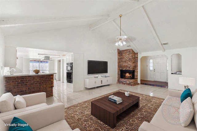 tiled living room with a fireplace, ceiling fan, sink, high vaulted ceiling, and beamed ceiling