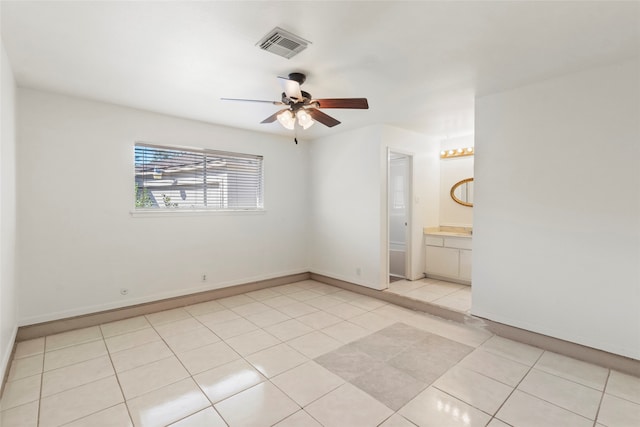 unfurnished bedroom with light tile patterned floors, connected bathroom, and ceiling fan