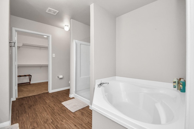 bathroom with hardwood / wood-style flooring and separate shower and tub