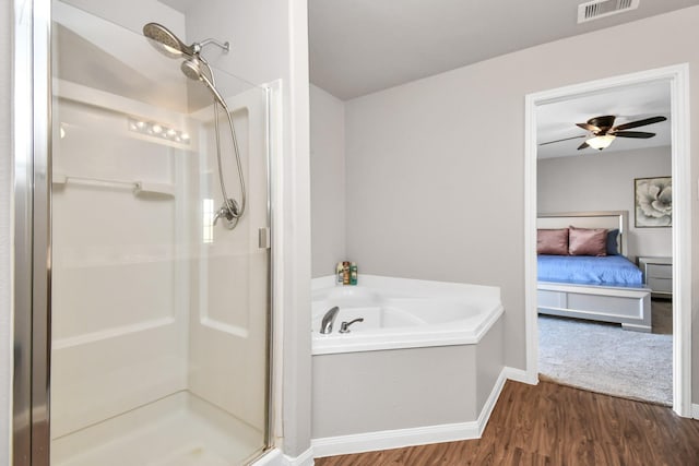 bathroom with ceiling fan, separate shower and tub, and wood-type flooring