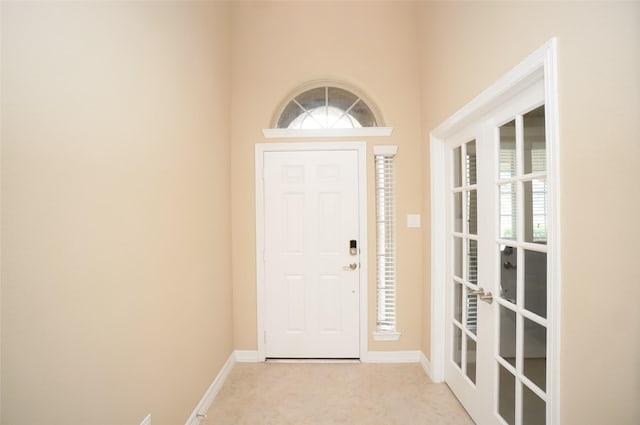 entrance foyer with light colored carpet and a healthy amount of sunlight