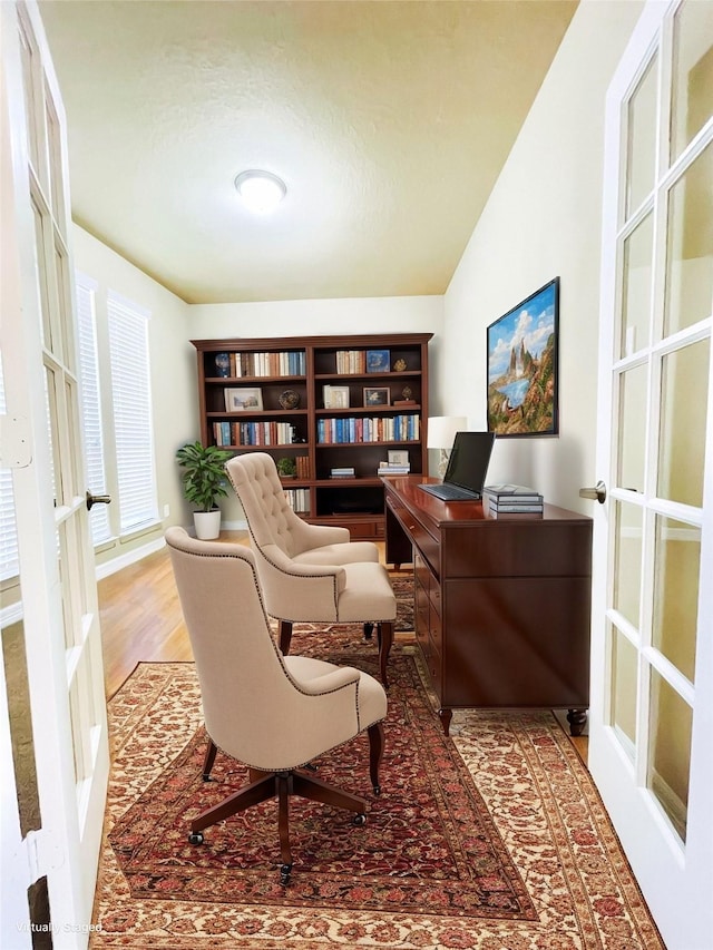 living area featuring french doors, lofted ceiling, and wood-type flooring