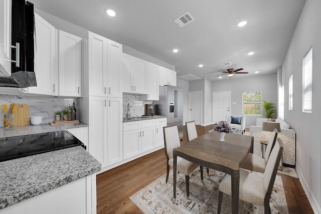 dining room with ceiling fan, dark hardwood / wood-style flooring, and sink