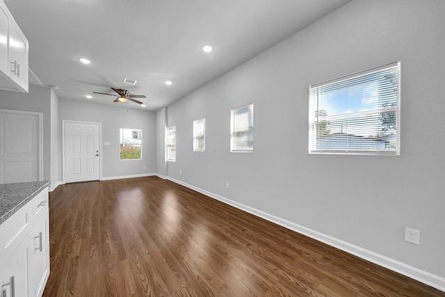 unfurnished living room with dark hardwood / wood-style flooring and ceiling fan