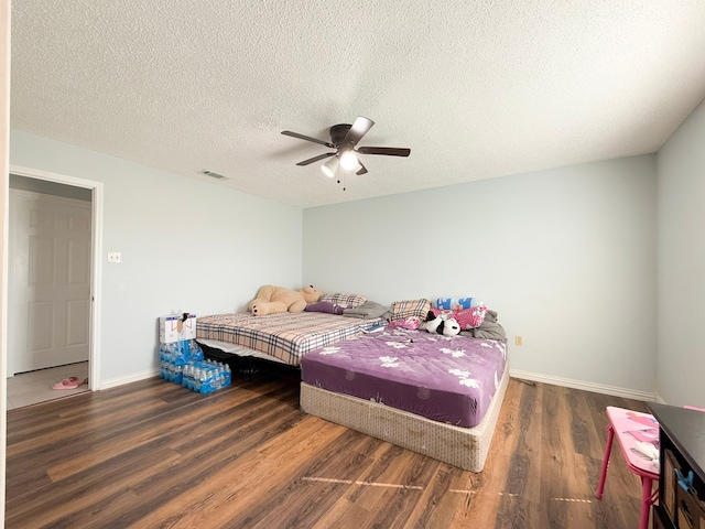 bedroom with a textured ceiling, dark hardwood / wood-style flooring, and ceiling fan