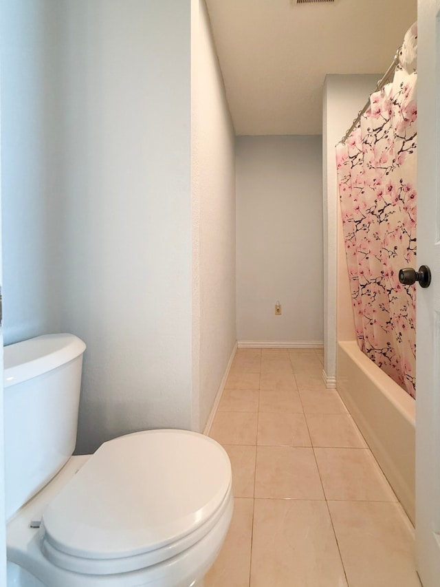 bathroom with tile patterned floors, shower / tub combo with curtain, and toilet