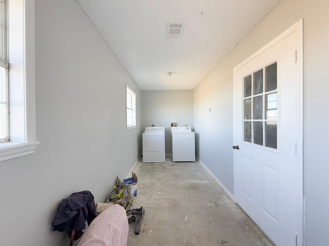 laundry room featuring a textured ceiling and washer and clothes dryer