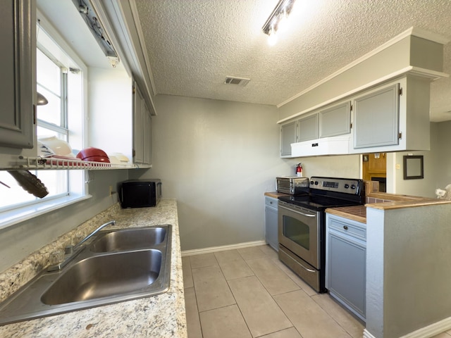 kitchen with electric stove, sink, gray cabinetry, and a textured ceiling