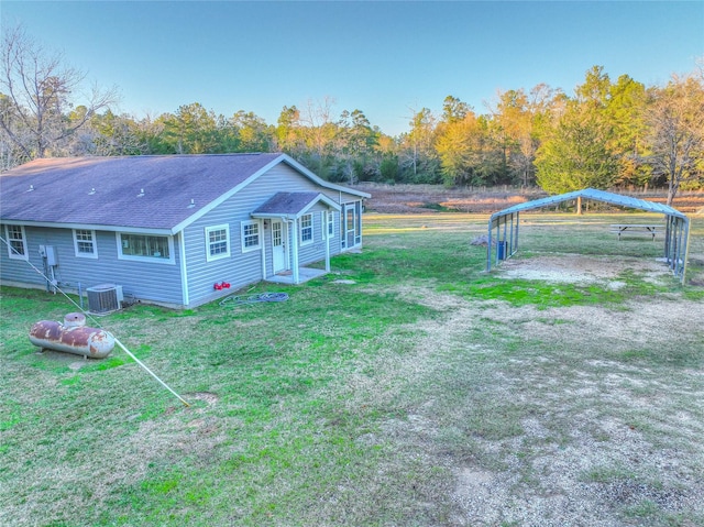 view of yard featuring central AC unit and a carport