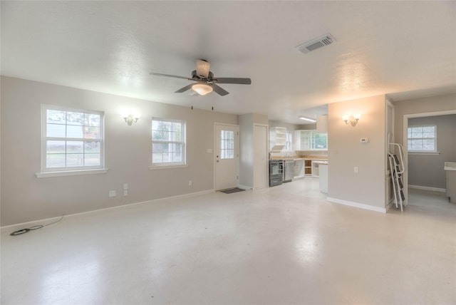 unfurnished living room with a textured ceiling, ceiling fan, and a healthy amount of sunlight