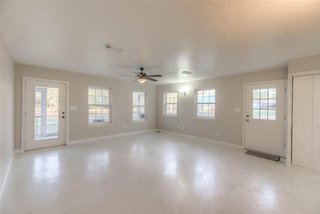 foyer entrance with a healthy amount of sunlight, baseboards, visible vents, and a ceiling fan