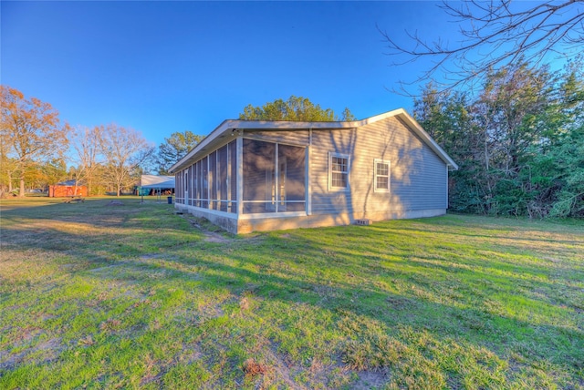 rear view of house with a sunroom and a yard