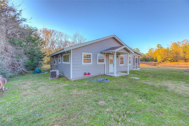 view of front of property featuring a front yard and central AC