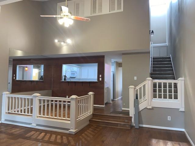 entrance foyer with ceiling fan, dark hardwood / wood-style flooring, and high vaulted ceiling