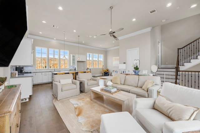 living room with light hardwood / wood-style floors, ceiling fan, ornamental molding, and sink