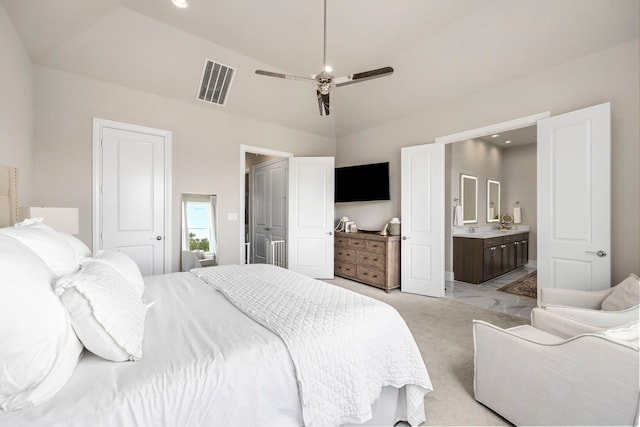 carpeted bedroom with connected bathroom, ceiling fan, and high vaulted ceiling