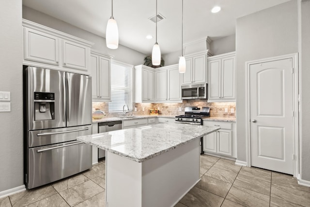 kitchen with a center island, sink, hanging light fixtures, white cabinetry, and stainless steel appliances