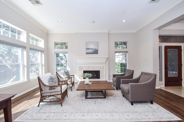 living room featuring a healthy amount of sunlight, crown molding, and light hardwood / wood-style flooring