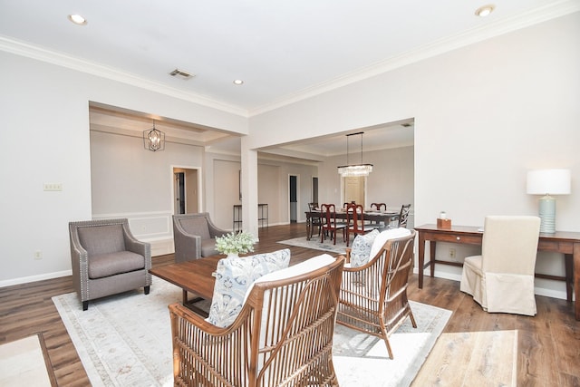 living room featuring a chandelier, light wood-type flooring, and crown molding