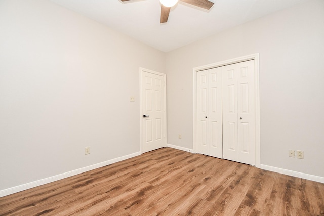 unfurnished bedroom featuring hardwood / wood-style floors, a closet, and ceiling fan