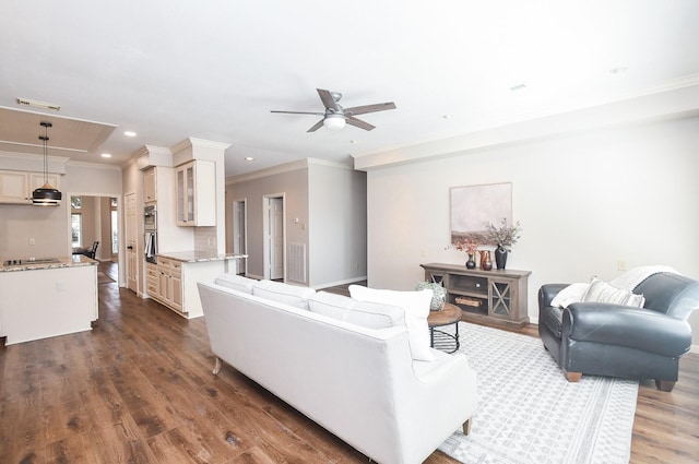 living room with ornamental molding, ceiling fan, and dark wood-type flooring