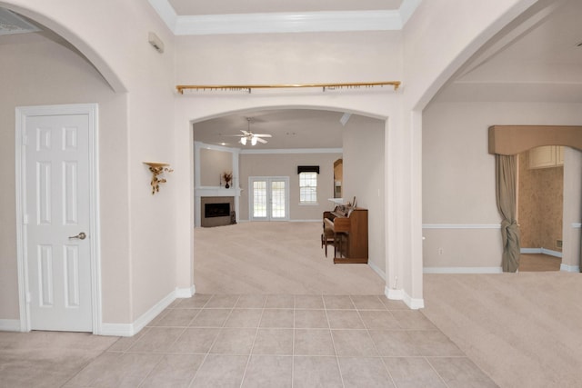 carpeted entrance foyer featuring ornamental molding and ceiling fan