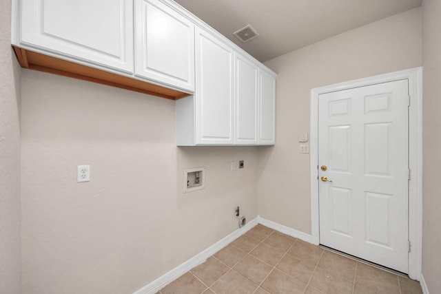 laundry room with gas dryer hookup, light tile patterned floors, hookup for a washing machine, cabinets, and hookup for an electric dryer