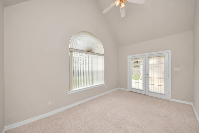 carpeted empty room featuring vaulted ceiling, ceiling fan, and french doors