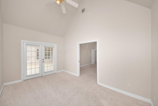 carpeted spare room featuring ceiling fan, high vaulted ceiling, and french doors