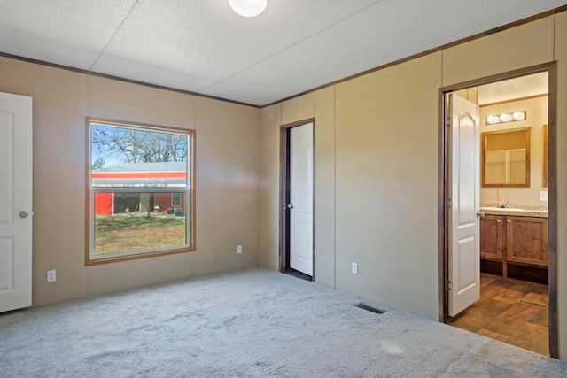 unfurnished bedroom featuring carpet flooring and connected bathroom