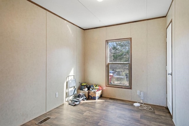 spare room with hardwood / wood-style flooring and ornamental molding