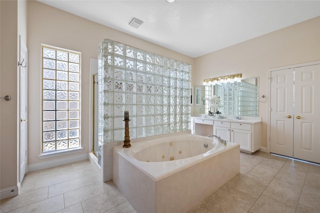 bathroom featuring vanity, tile patterned flooring, and plus walk in shower