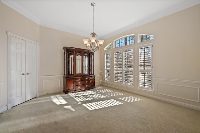 carpeted empty room featuring an inviting chandelier and ornamental molding