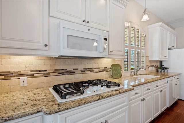 kitchen with backsplash, white appliances, and white cabinets